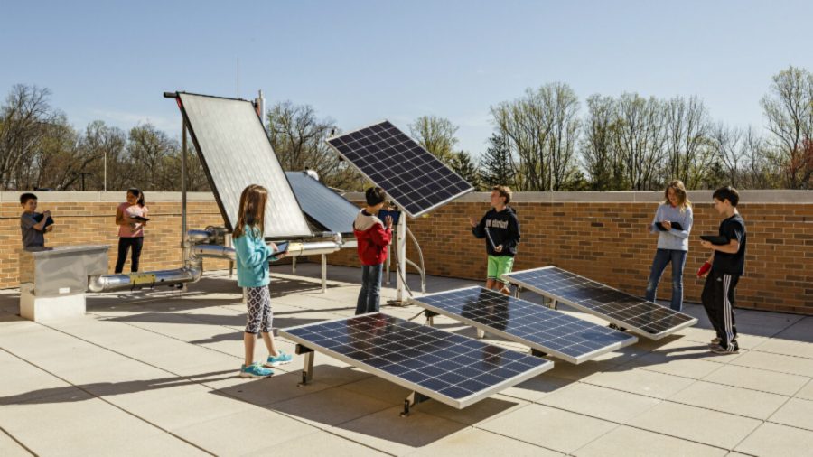 Kids show off solar panels at their school.