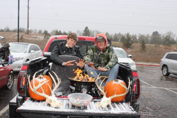 Bryce Swanson and Talan Lunders stay warm while handing out candy. 
